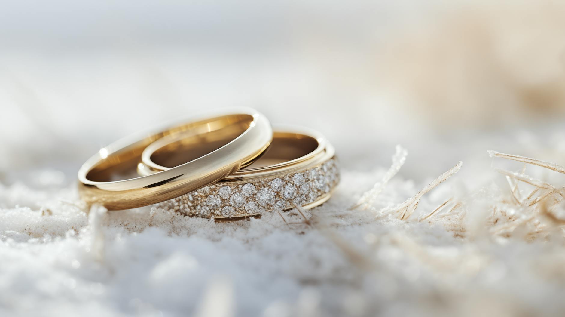 close up of wedding rings lying on a snowy surface